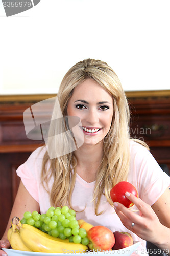 Image of Smiling young woman with a bowl of fruit