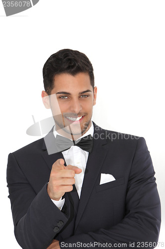 Image of Handsome man in a tuxedo pointing