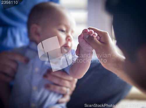 Image of Cute Mixed Race Infant Boy Holds Father's Thumb