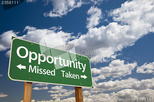 Image of Opportunity Missed and Taken Green Road Sign and Clouds