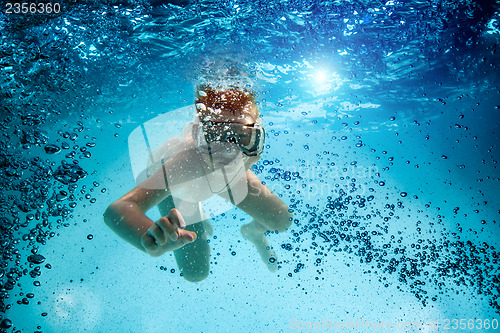 Image of Teenager in the mask and snorkel swim underwater.