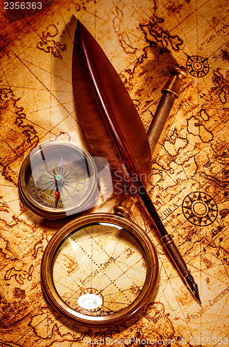 Image of Vintage magnifying glass lies on an ancient world map