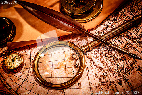 Image of Vintage magnifying glass lies on an ancient world map