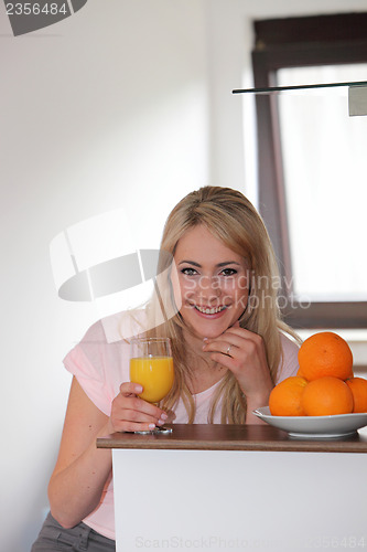 Image of Smiling woman drinking orange juice