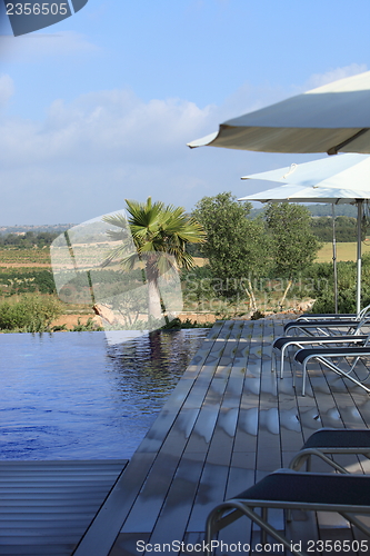 Image of Recliners and beach umbrellas poolside