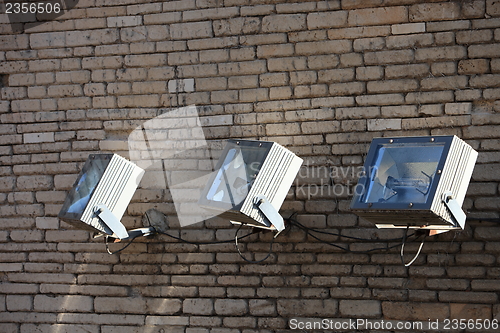 Image of Three spotlights on a brick wall