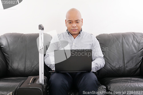 Image of african travel businessman working in airport vip lounge