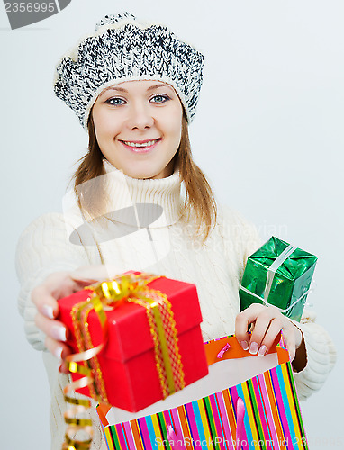 Image of attractive girl in a sweater holding a gift