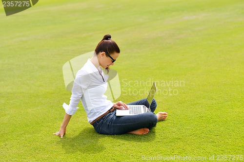 Image of woman with laptop in park