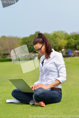 Image of woman with laptop in park