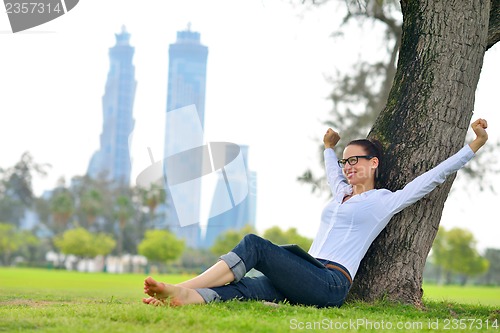 Image of Beautiful young woman with  tablet in park