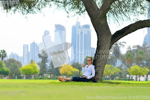 Image of woman with laptop in park