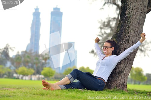 Image of Beautiful young woman with  tablet in park