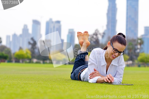 Image of Beautiful young woman with  tablet in park