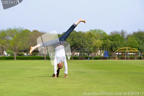 Image of young woman jumping in park