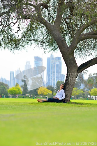 Image of woman with laptop in park