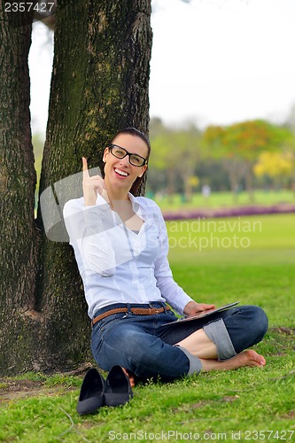 Image of Beautiful young woman with  tablet in park