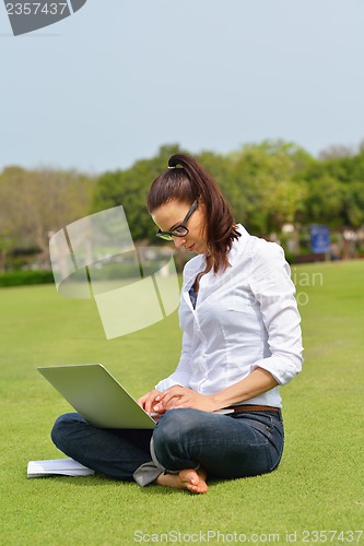 Image of woman with laptop in park