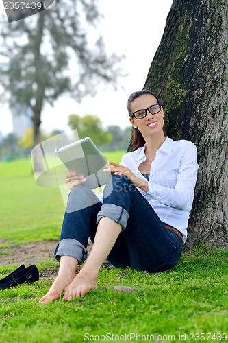 Image of Beautiful young woman with  tablet in park