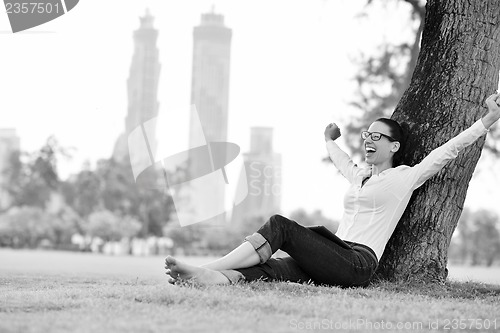 Image of Beautiful young woman with  tablet in park