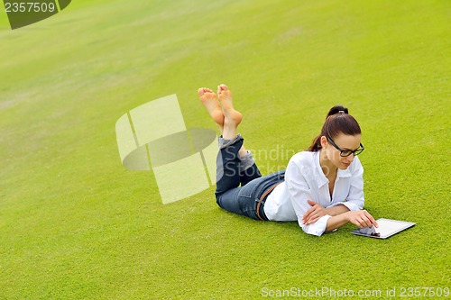 Image of Beautiful young woman with  tablet in park