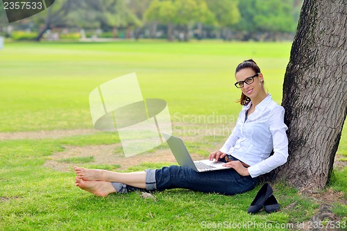 Image of woman with laptop in park