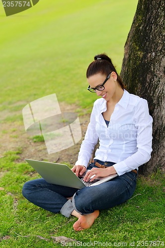 Image of woman with laptop in park