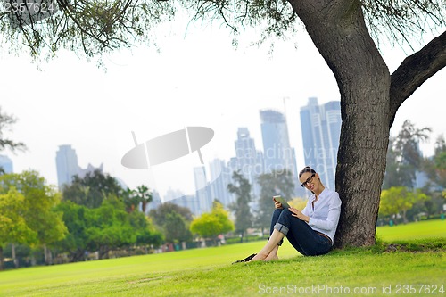 Image of Beautiful young woman with  tablet in park