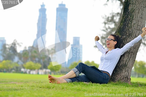 Image of Beautiful young woman with  tablet in park