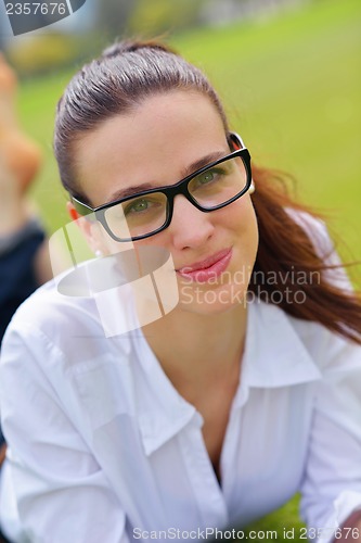 Image of Young woman reading a book in the park