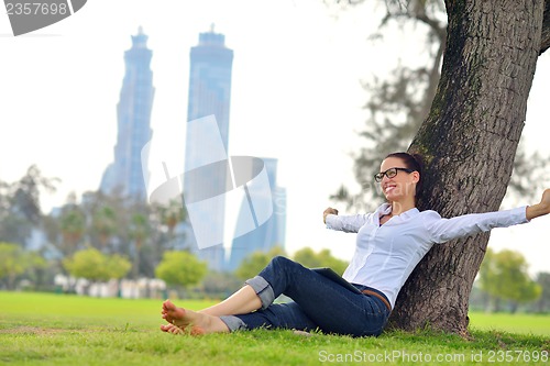 Image of Beautiful young woman with  tablet in park