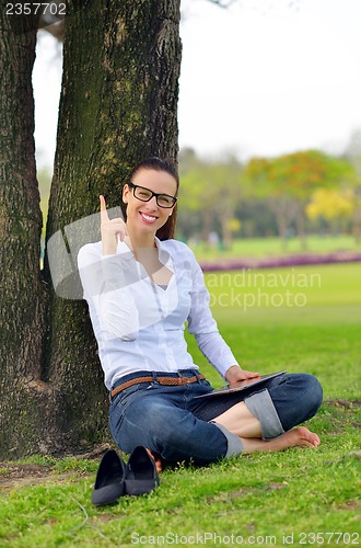 Image of Beautiful young woman with  tablet in park