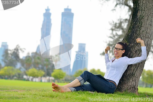 Image of Beautiful young woman with  tablet in park