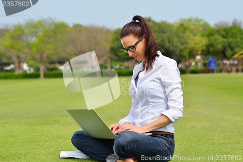 Image of woman with laptop in park