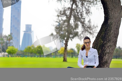 Image of Beautiful young woman with  tablet in park