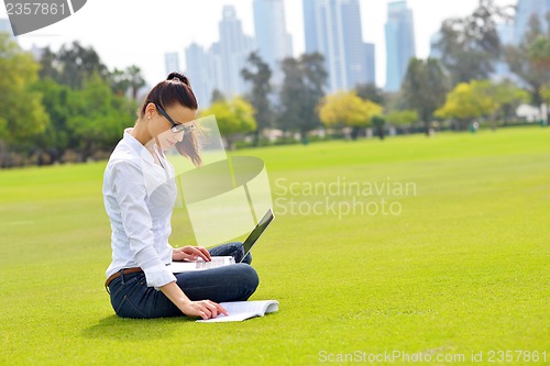 Image of woman with laptop in park