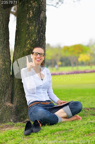 Image of Beautiful young woman with  tablet in park