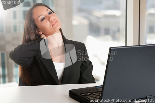 Image of Businesswoman Sitting at Her Desk Tired