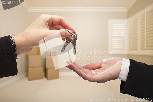 Image of Woman Handing Over the House Keys Inside Empty Tan Room