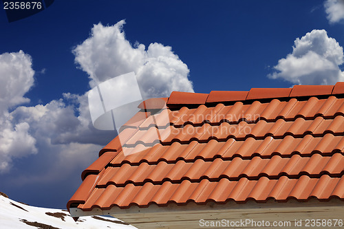Image of Roof tiles and blue sky with clouds