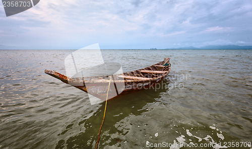 Image of Empty old wooden boat on the waves