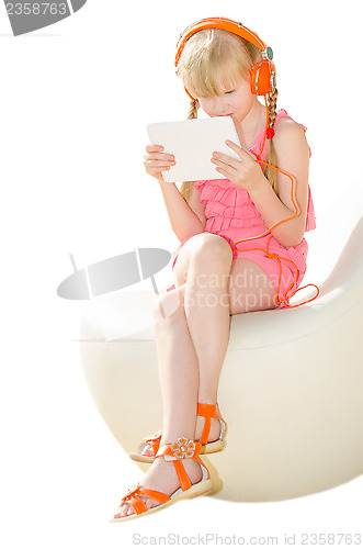 Image of Girl with tablet PC watching video in headphones isolated