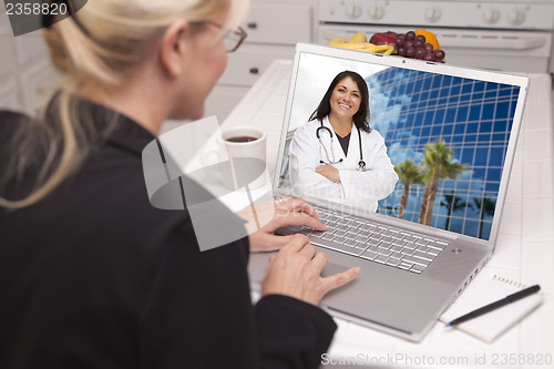 Image of Woman In Kitchen Using Laptop - Online with Nurse or Doctor