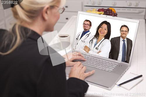 Image of Woman In Kitchen Using Laptop, Online with Nurses or Doctors