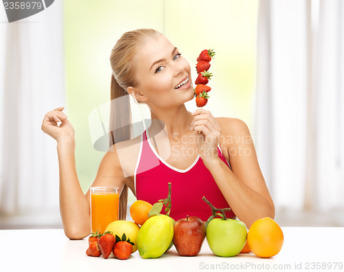 Image of woman with organic food eating strawberry