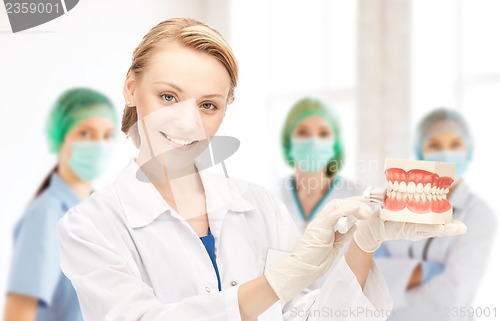 Image of doctor with toothbrush and jaws in hospital