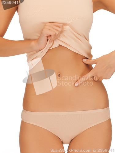 Image of woman pointing at her abs