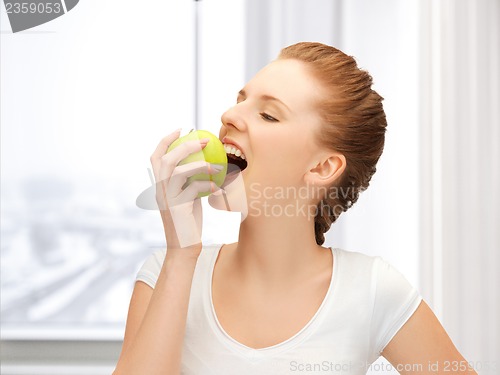 Image of teenage girl biting a green apple