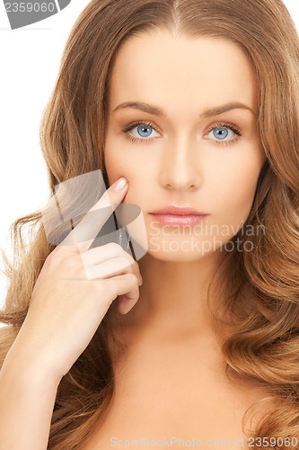 Image of woman pointing at her cheek