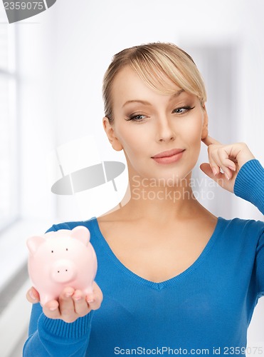 Image of lovely woman with piggy bank